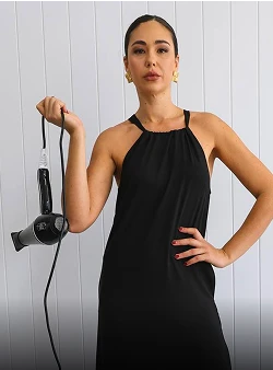 woman holding hair blower while wearing savvy industry clothing
